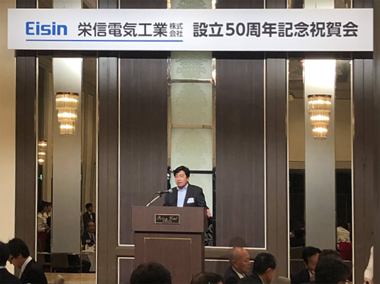 50周年記念式典でスピーチをしている様子の写真